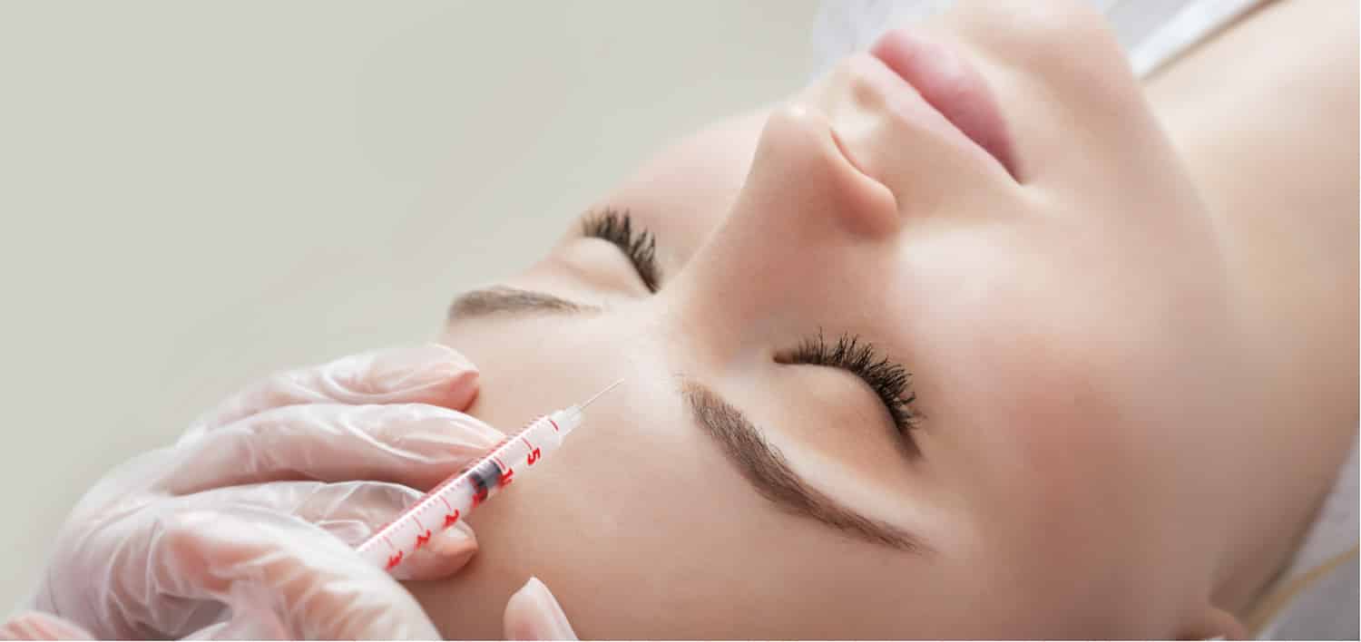A woman getting a Botulinum toxin injection in her forehead