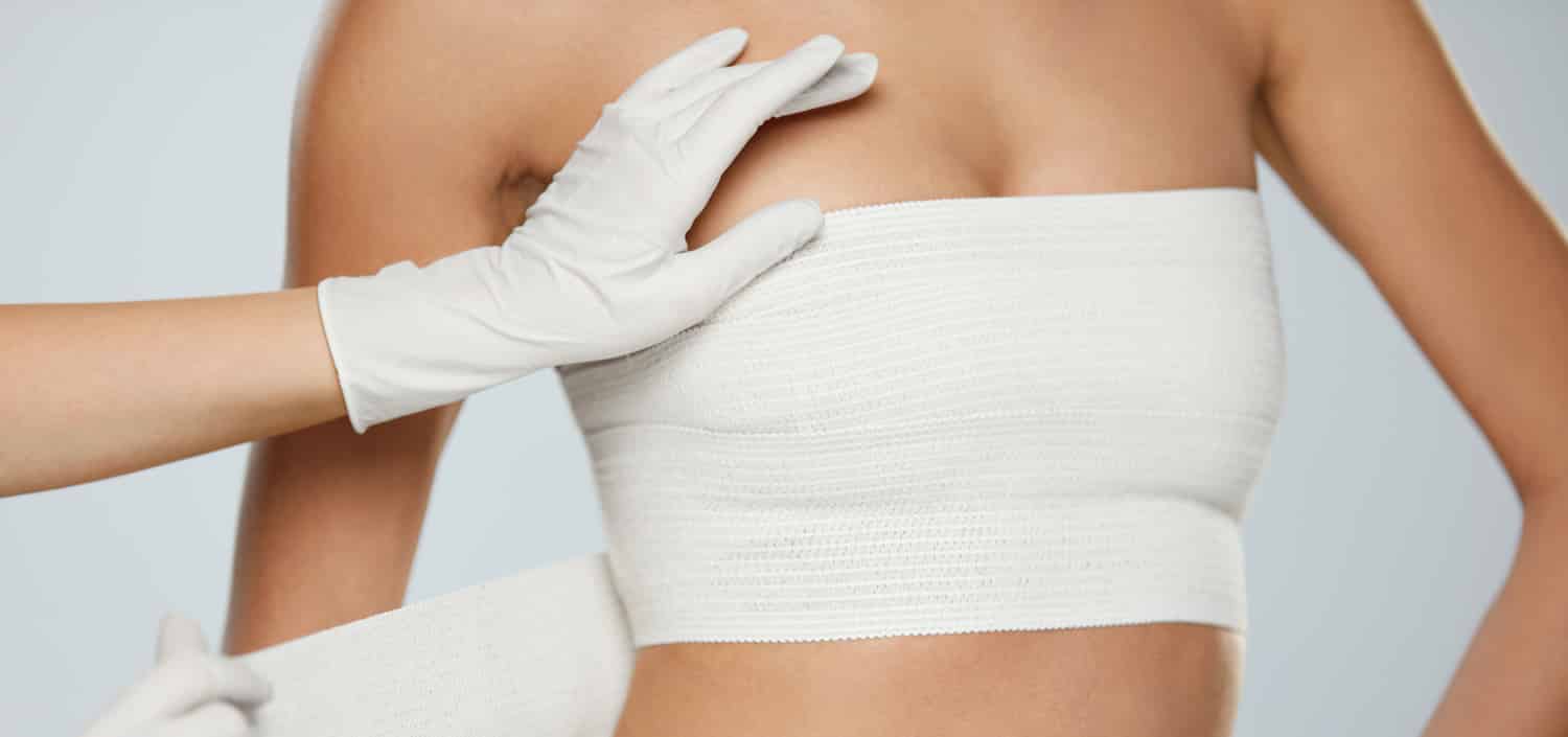A woman with bandages over her breasts after mastopexy (breast lift)