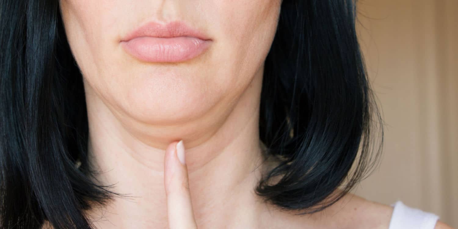 A woman pointing at her double chin