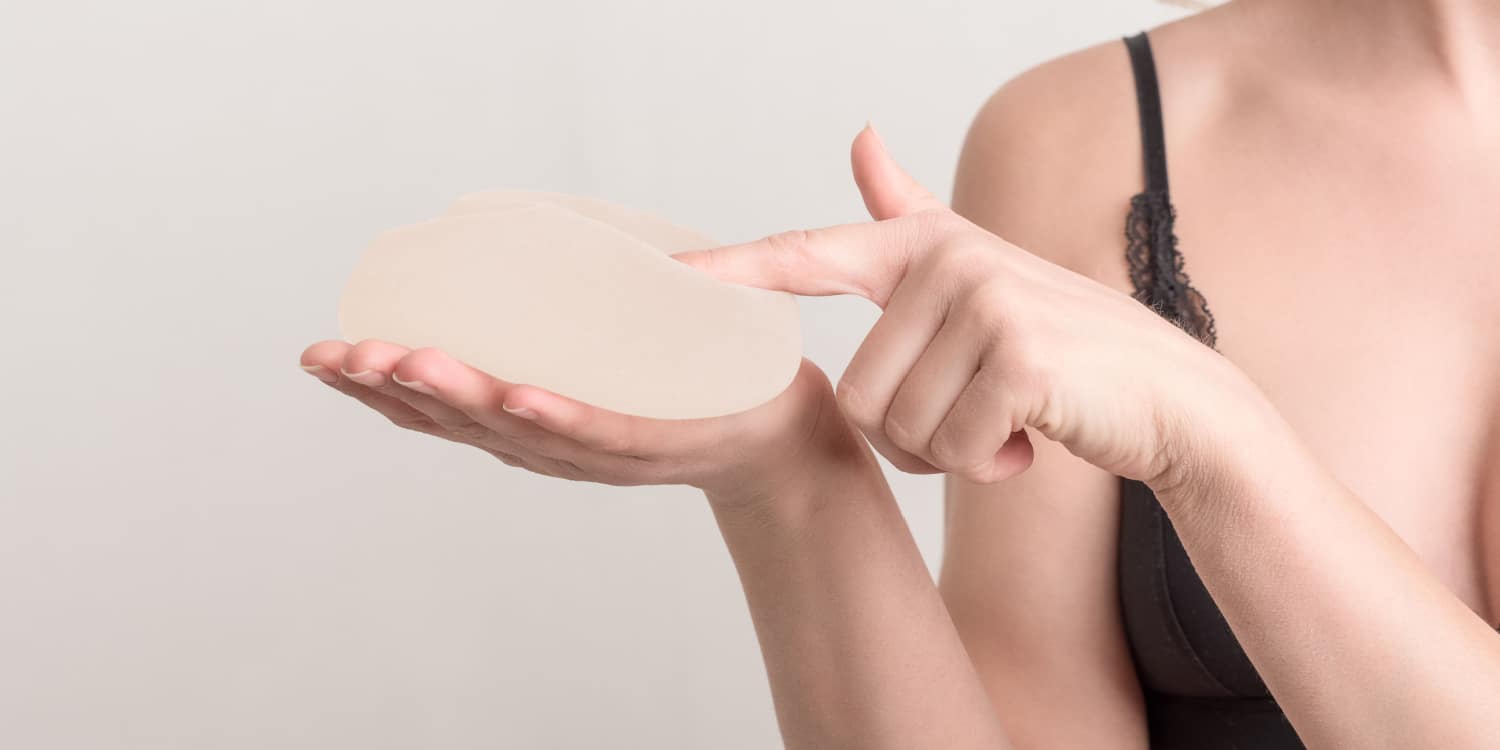 A woman holding a breast implant
