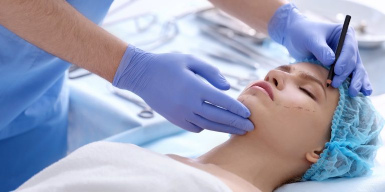 A board-certified plastic surgeon marking a woman for surgery