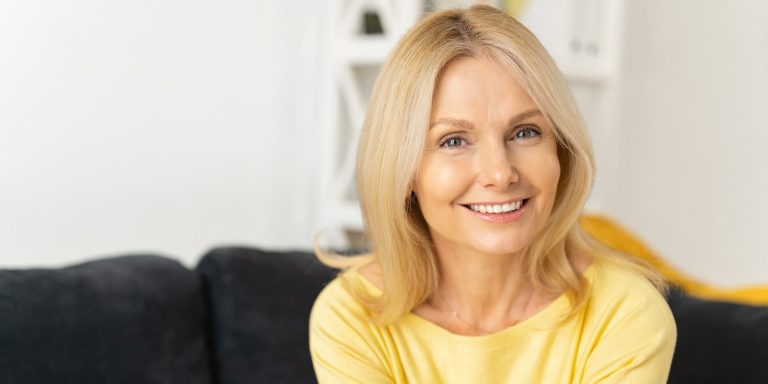 a beautiful older woman smiling after subtle plastic surgery from hess sandeen & lee